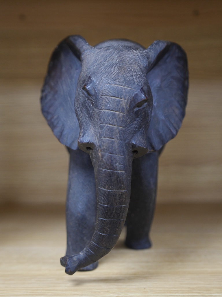 An African carved wood elephant, 27cm high. Condition - repaired section and tusks removed